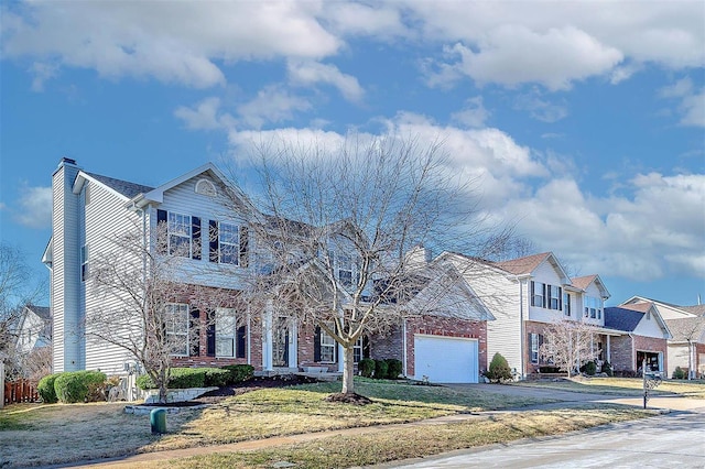 view of front of house with a garage, a chimney, aphalt driveway, a front lawn, and brick siding