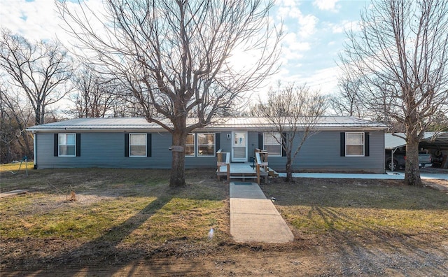 view of front of home with a front yard and metal roof