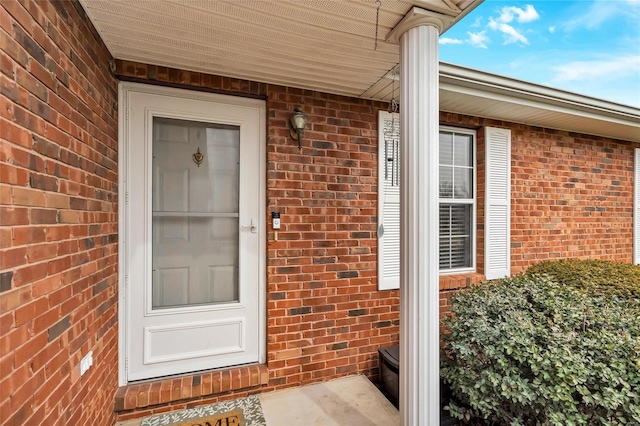 entrance to property featuring brick siding