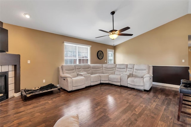 living room with lofted ceiling, a tiled fireplace, and wood finished floors