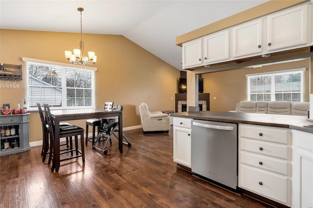 kitchen with a chandelier, dishwasher, dark wood-type flooring, vaulted ceiling, and white cabinetry