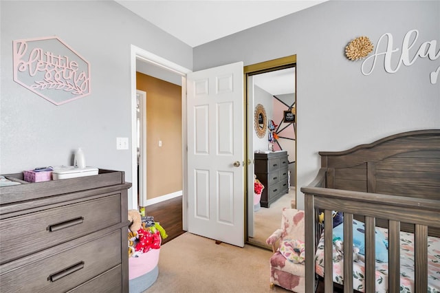 bedroom featuring baseboards, a closet, and light colored carpet