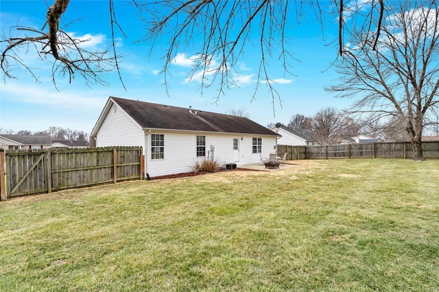 back of house with a patio area, a fenced backyard, a lawn, and a fire pit