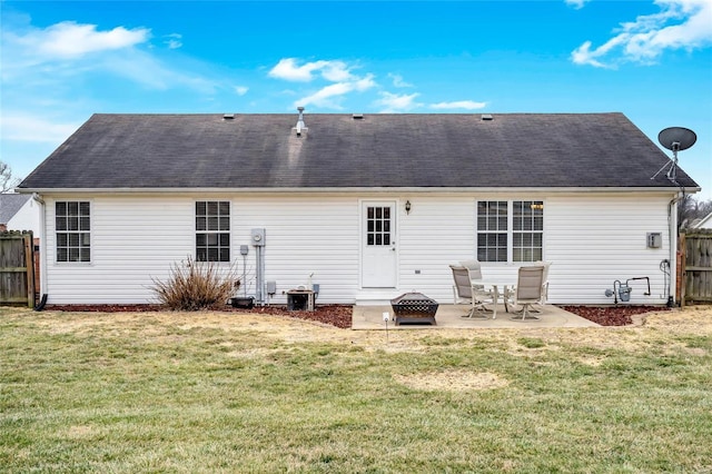 rear view of property with fence, a lawn, and a patio