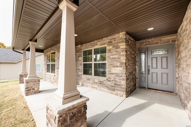 entrance to property with stone siding and covered porch