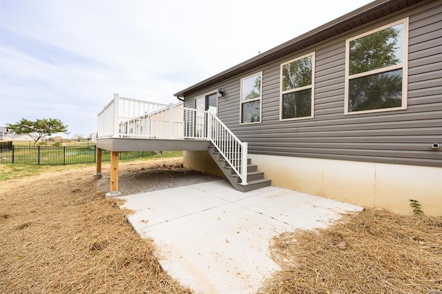 exterior space with a deck, a patio, and fence