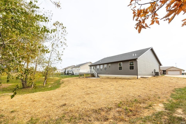 rear view of house with cooling unit and a garage