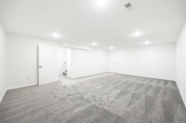 finished below grade area featuring carpet, visible vents, baseboards, recessed lighting, and stairs