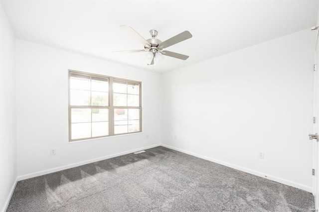 carpeted spare room featuring baseboards and ceiling fan