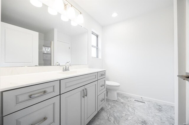 bathroom featuring visible vents, toilet, marble finish floor, baseboards, and vanity