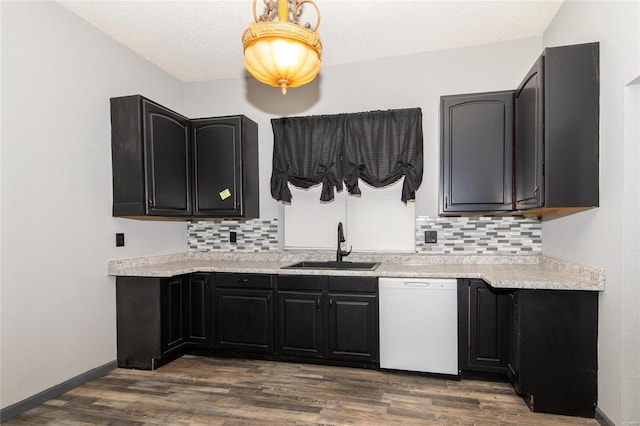 kitchen with a sink, dark wood-style floors, decorative backsplash, and dishwasher