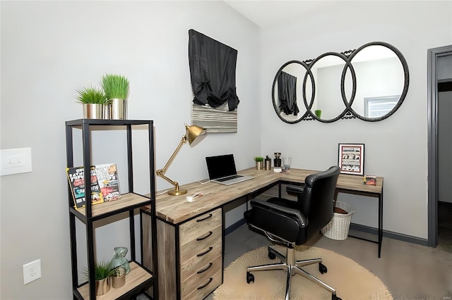 office space featuring finished concrete flooring and baseboards