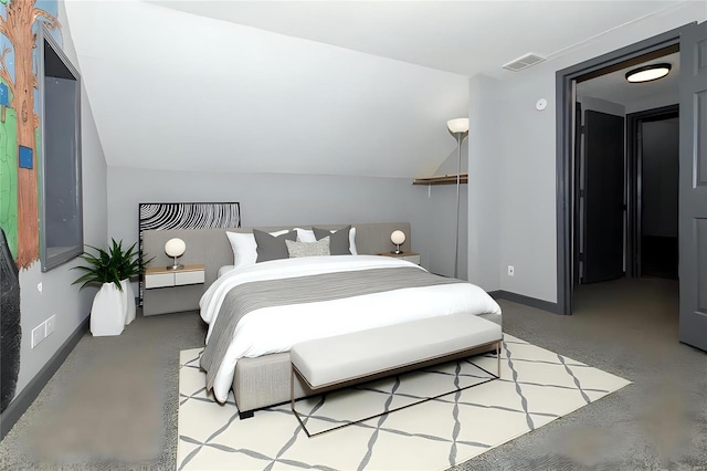 bedroom with finished concrete floors, visible vents, vaulted ceiling, and baseboards