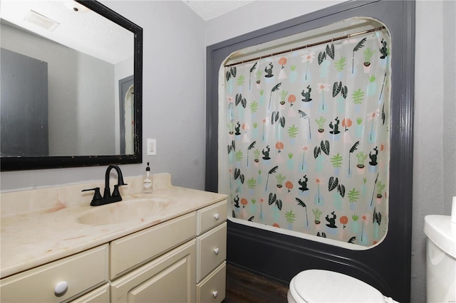 bathroom featuring toilet, shower / bathtub combination with curtain, visible vents, and vanity