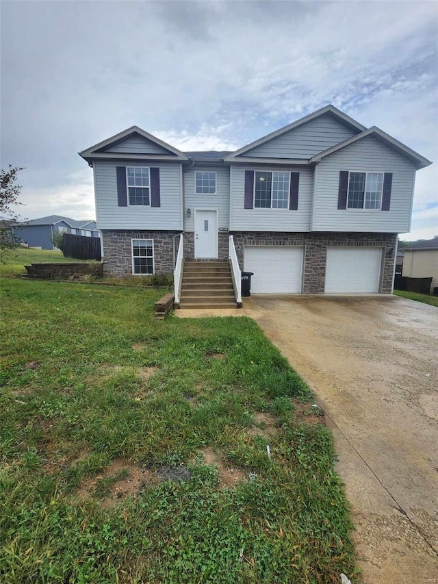 split foyer home with driveway, a front lawn, and an attached garage