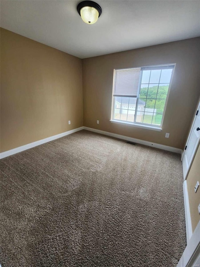 carpeted spare room with baseboards