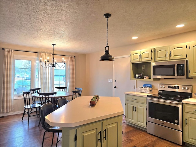 kitchen featuring dark wood-style floors, a kitchen island, hanging light fixtures, stainless steel appliances, and light countertops