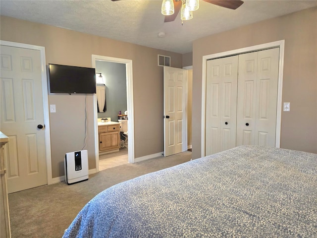 bedroom with a textured ceiling, light colored carpet, visible vents, baseboards, and a closet