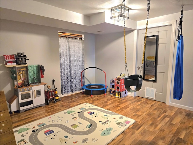 playroom with wood finished floors and visible vents