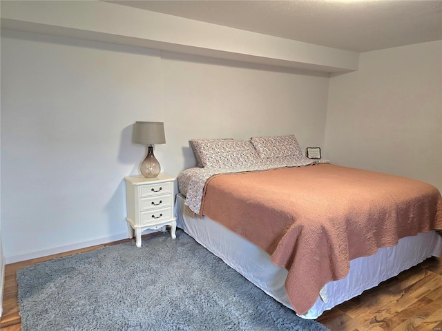 bedroom with wood finished floors and baseboards