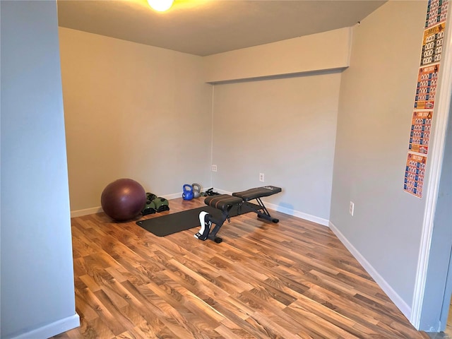 workout room featuring baseboards and wood finished floors