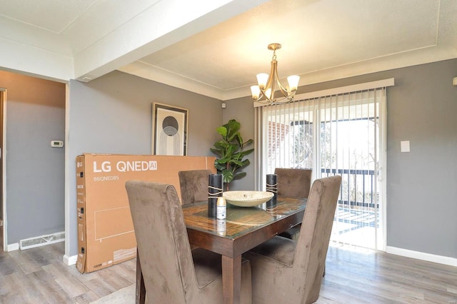 dining room with light wood finished floors, baseboards, and a chandelier