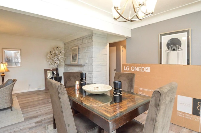 dining area featuring a chandelier, wood finished floors, and baseboards