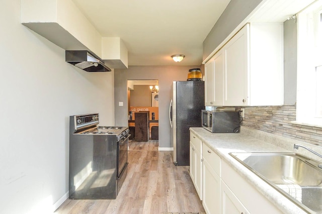 kitchen with tasteful backsplash, white cabinets, appliances with stainless steel finishes, light countertops, and a sink