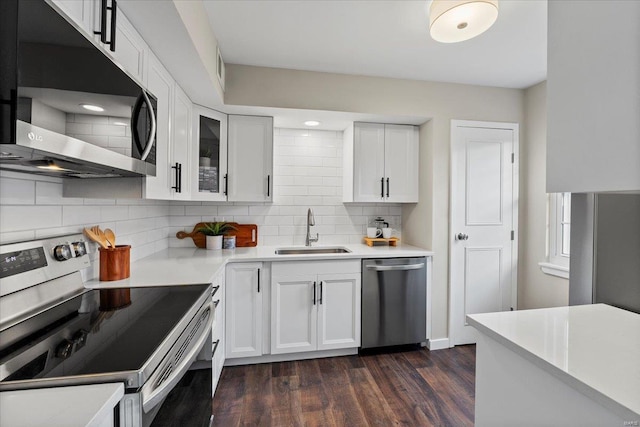 kitchen with a sink, white cabinetry, light countertops, appliances with stainless steel finishes, and backsplash