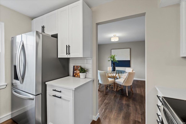 kitchen featuring tasteful backsplash, dark wood-style floors, stainless steel appliances, light countertops, and white cabinetry