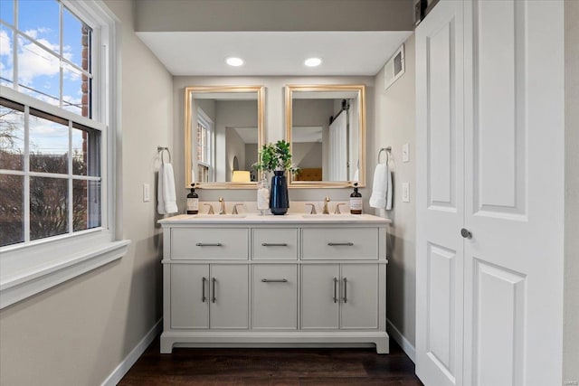 full bathroom with visible vents, a sink, baseboards, and double vanity