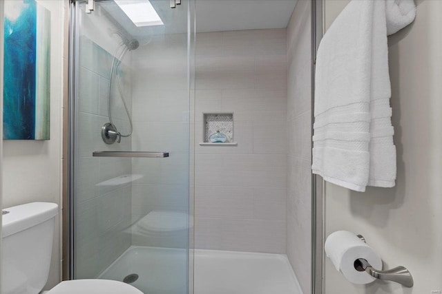 bathroom with toilet and a stall shower