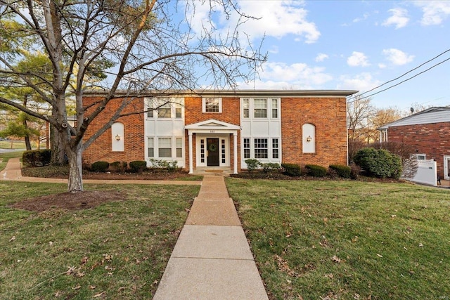 view of front of home featuring a front yard and brick siding