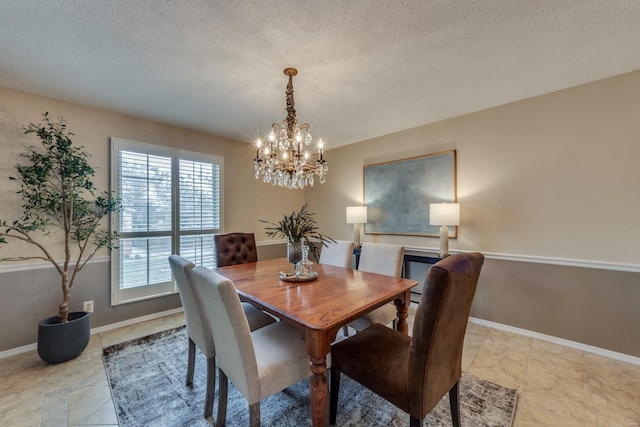 dining room featuring baseboards, a chandelier, and a textured ceiling