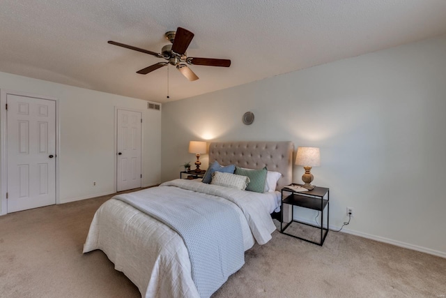 carpeted bedroom featuring visible vents, ceiling fan, a textured ceiling, and baseboards