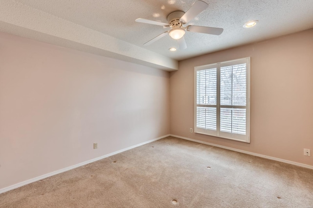 carpeted spare room with a textured ceiling, recessed lighting, a ceiling fan, and baseboards