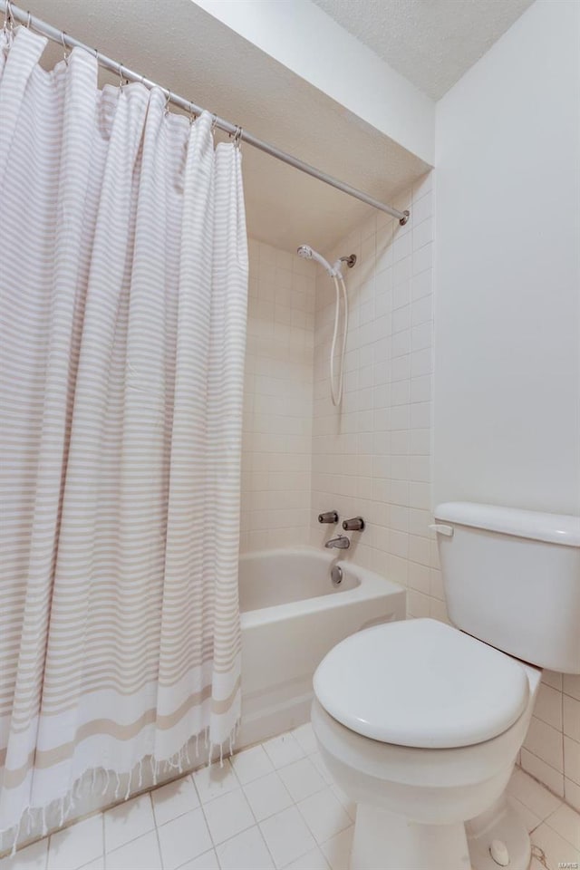 bathroom featuring a textured ceiling, shower / bath combo with shower curtain, toilet, and tile patterned floors