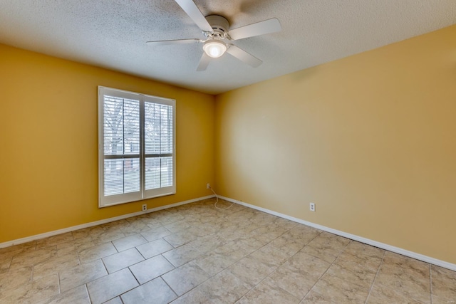 spare room with ceiling fan, a textured ceiling, and baseboards