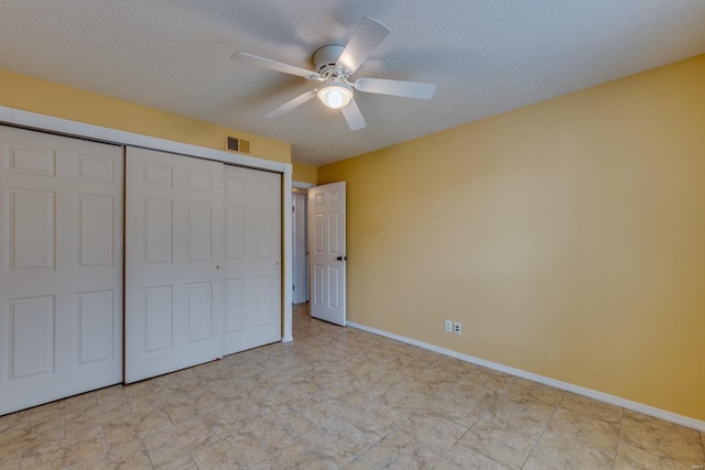 unfurnished bedroom with a closet, visible vents, ceiling fan, a textured ceiling, and baseboards