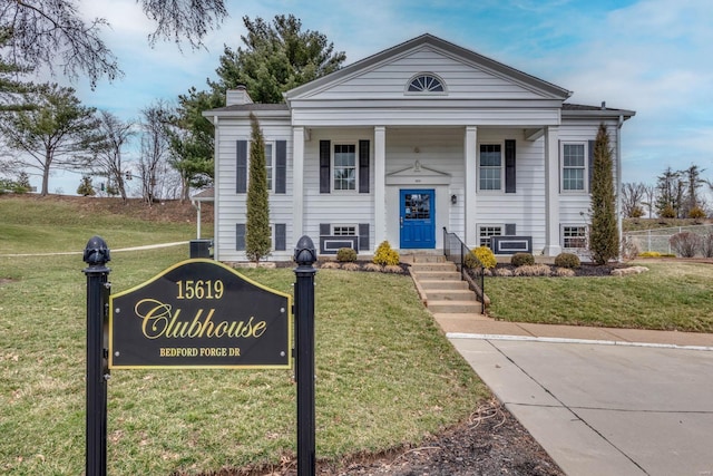 view of front of house featuring a chimney, a front lawn, and central AC