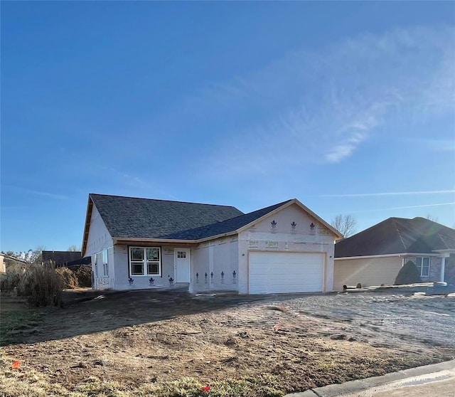 property in mid-construction featuring driveway, an attached garage, and stucco siding