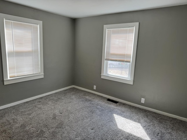 carpeted empty room with baseboards and visible vents