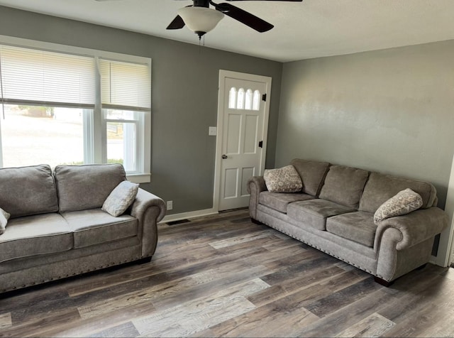 living area with wood finished floors, a ceiling fan, and baseboards