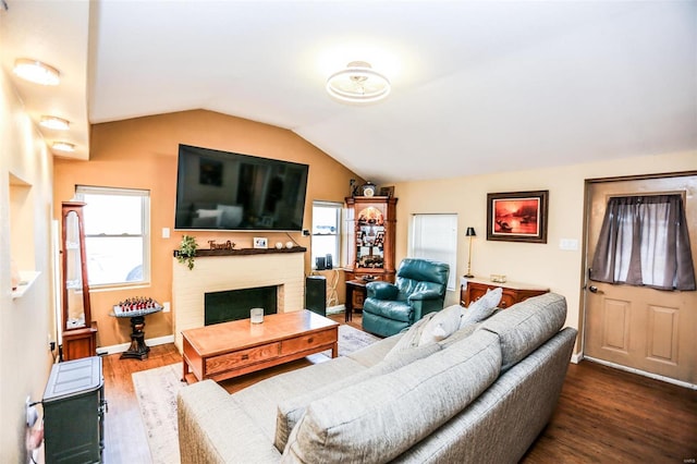 living area with baseboards, lofted ceiling, wood finished floors, and a fireplace