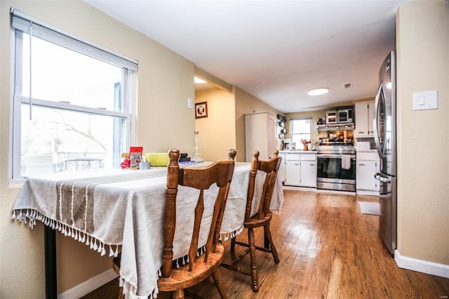 dining room with baseboards and wood finished floors