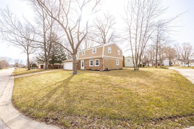 view of front of home featuring a front yard, an attached garage, brick siding, and driveway