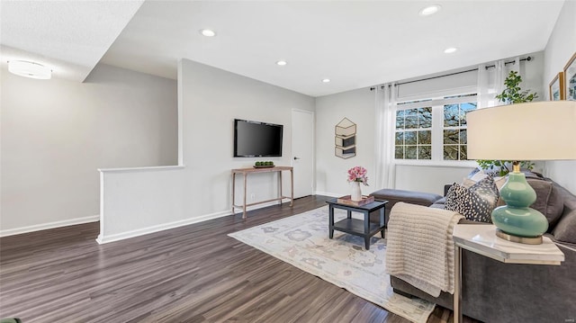 living area with baseboards, wood finished floors, and recessed lighting