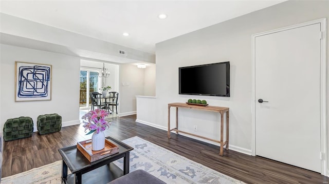 living area with a notable chandelier, recessed lighting, wood finished floors, visible vents, and baseboards