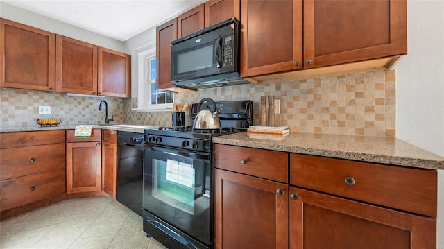 kitchen featuring light tile patterned floors, black appliances, light stone countertops, and decorative backsplash