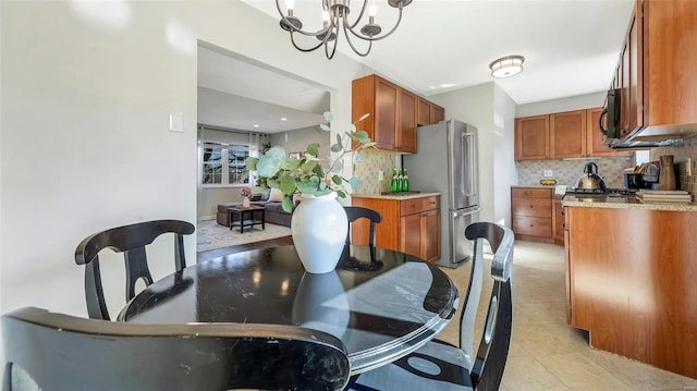 dining space with light tile patterned floors and a notable chandelier